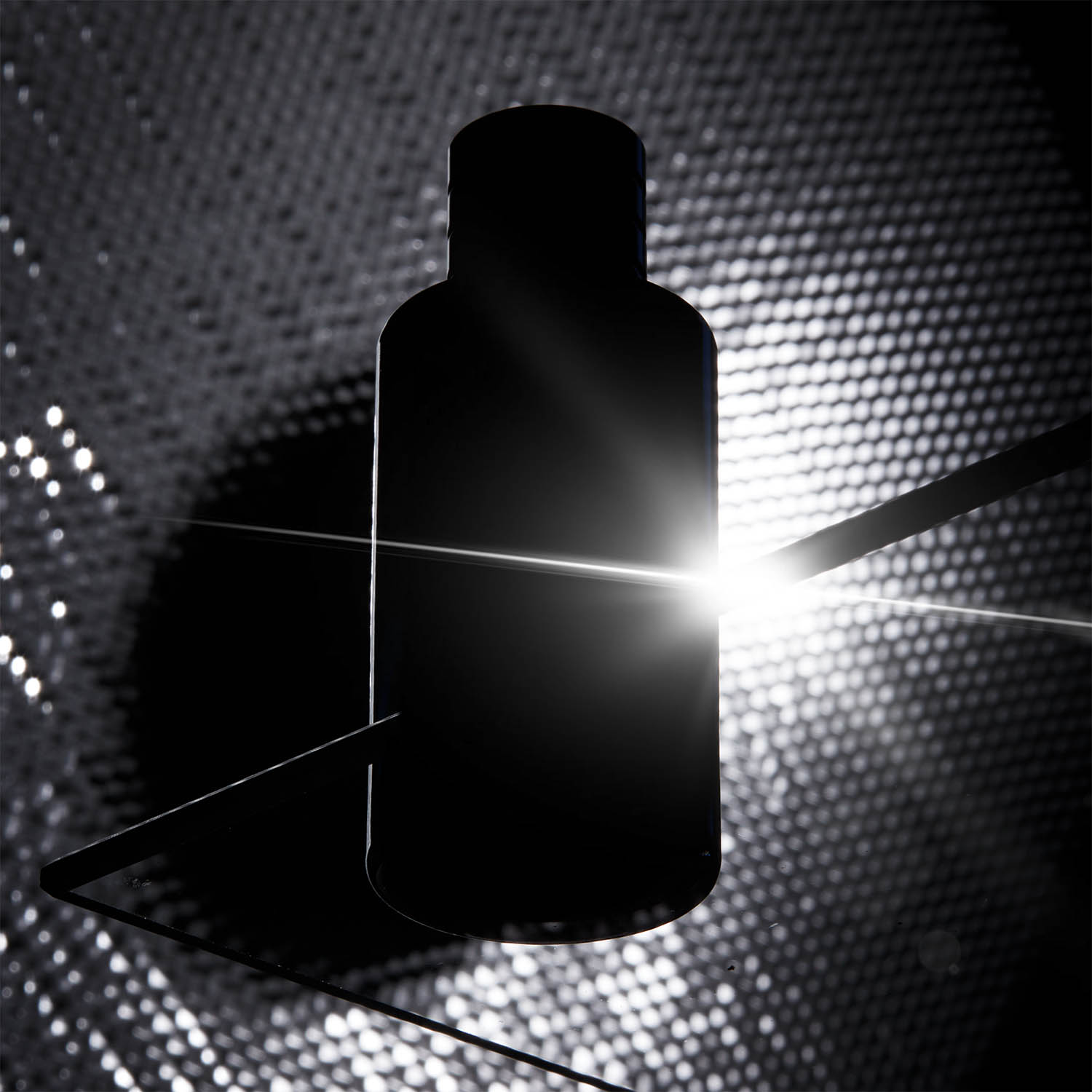 Représentation d'un flacon de parfum en studio à contre-jour